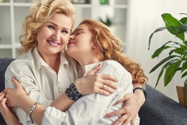 Reife Frau umarmt Tochter zu Hause — Stockfoto