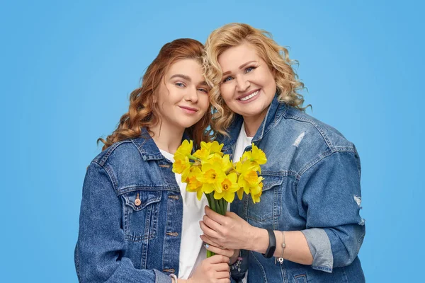 Nenek dan cucu yang bergaya positif menikmati bunga bersama Stok Gambar