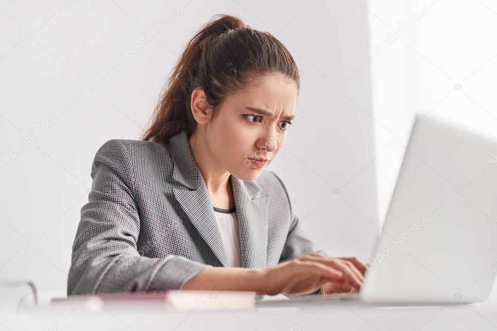 Strained trainee using laptop in office