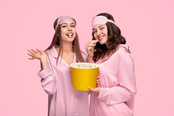 Vrolijke vriendinnen die popcorn eten tijdens een sleepover — Stockfoto