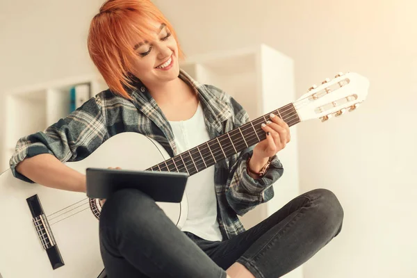 Allegro femminile imparare a suonare la chitarra a casa — Foto Stock