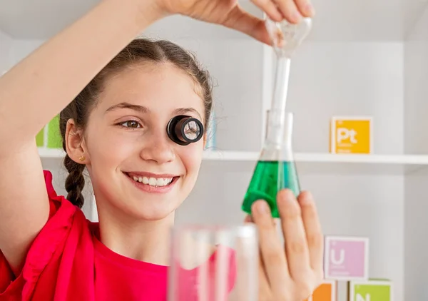 Uśmiechnięta dziewczyna z obiektywem przewodzącego eksperyment chemiczny — Zdjęcie stockowe