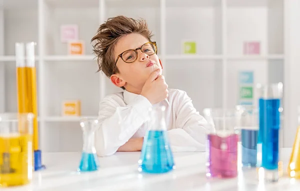 Kimya laboratuvarında düşünceli küçük bilim adamı — Stok fotoğraf