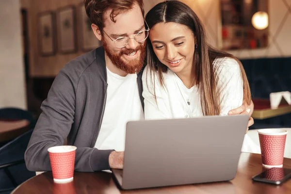 Młoda para przeglądając laptopa w kawiarni — Zdjęcie stockowe