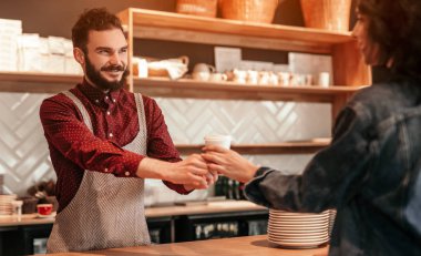 Müşteriye içki veren gülümseyen barista