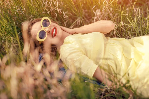 Senhora elegante descansando no campo e sorrindo — Fotografia de Stock