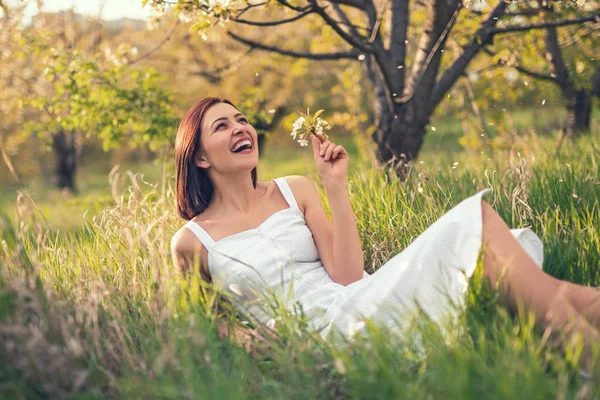 Bahçede çimenlerin üzerinde yatan gülen kadın — Stok fotoğraf