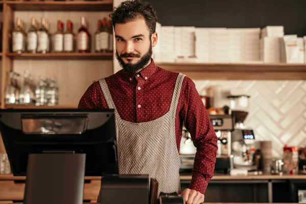 Cajero barbudo trabajando en la cafetería — Foto de Stock