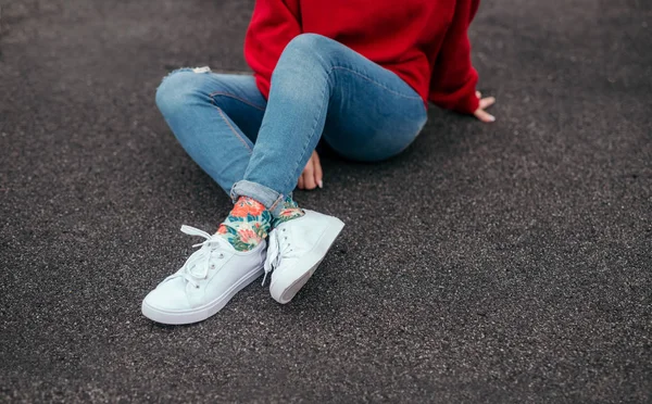 Beskär hipster sittande på asfalt — Stockfoto
