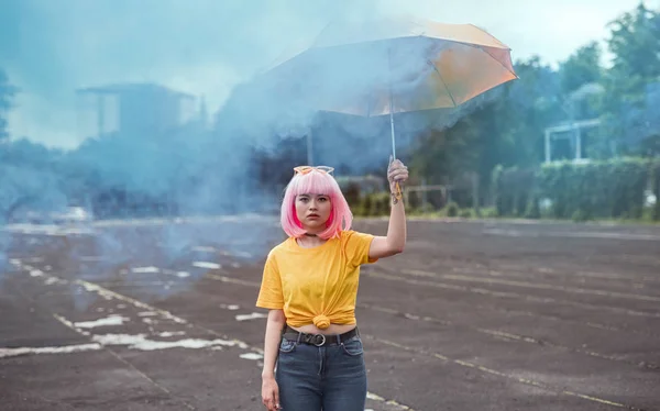 Azjatycki Hipster z parasolem w pobliżu niebieskiego dymu — Zdjęcie stockowe