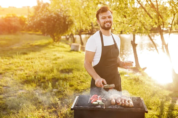 Mutlu erkek doğada brazier üzerinde barbekü hazırlanıyor — Stok fotoğraf