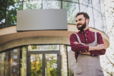 Kafenin dışında duran kendinden emin garson