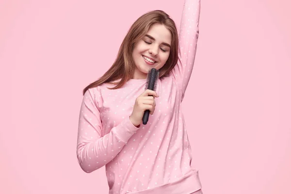 Mulher alegre imitando cantar com escova de cabelo — Fotografia de Stock