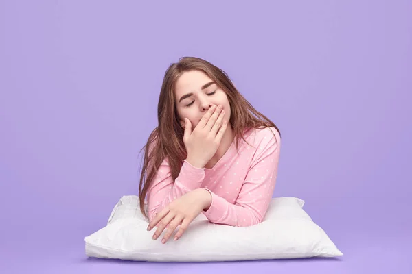 Teen girl gähnen auf kissen — Stockfoto