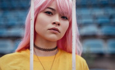 Kentsel genç çit arkasında kamera bakıyor