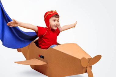 Karton uçakta uçan küçük pilot