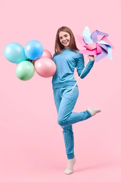 Wesoła dziecinny Kobieta w piżamie obchodzi balony i zabawki PIN — Zdjęcie stockowe