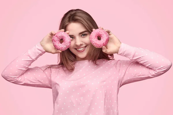 Menina adolescente feliz demonstrando donuts de manhã — Fotografia de Stock