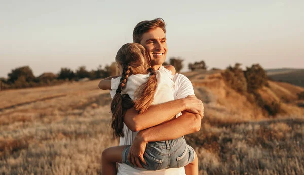 Happy father hugging daughter in field — Stock Photo, Image