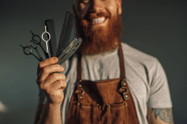 Cheerful barber showing set of tools — Stok fotoğraf