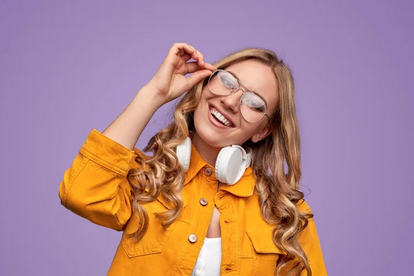 Mujer joven optimista ajustando gafas — Foto de Stock