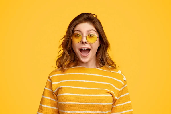 Amused woman in bright clothes and sunglasses looking at camera — Stock Photo, Image