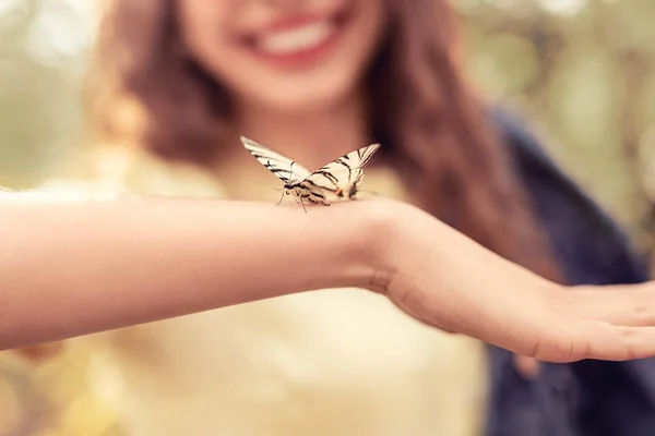 Butterfly sitter på armar av kvinnan — Stockfoto