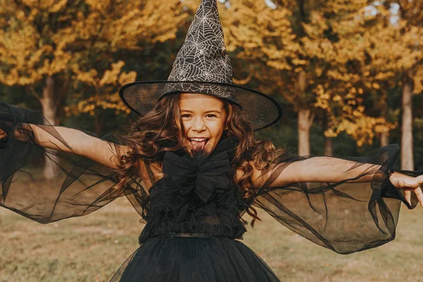 Menina bonito no traje de bruxa no fundo da natureza — Fotografia de Stock