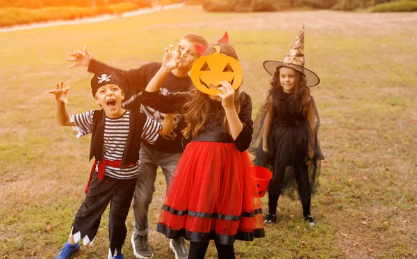 Kinderen in carnaval kostuums staan met pompoen masker — Stockfoto