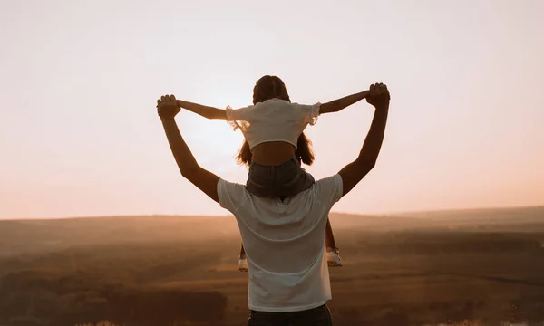 Père anonyme avec sa fille au coucher du soleil dans la nature — Photo