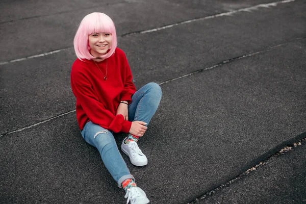 Joven hembra con pelo rosa sentada en el suelo — Foto de Stock