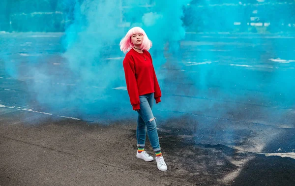 Adolescente étnico caminando contra el humo azul — Foto de Stock