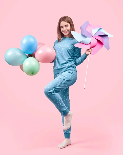 Женщина с воздушными шарами и разноцветным вертушкой — стоковое фото