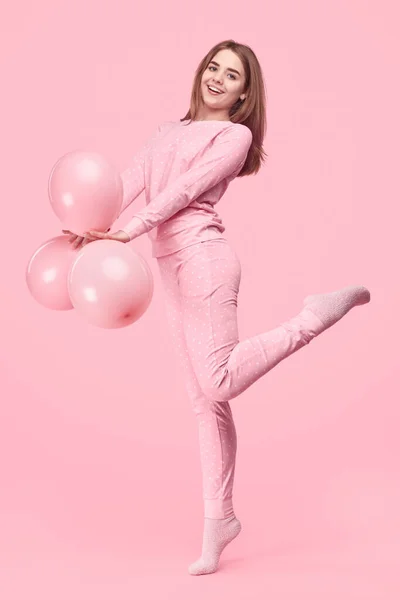 Adolescente alegre em pijama segurando balões — Fotografia de Stock