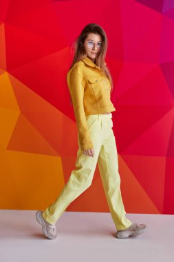 Geometrik duvarın yanında yürüyen şık bayan.