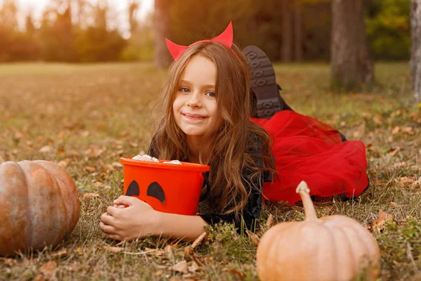 Gelukkige duivel met snoep vieren Halloween in het park — Stockfoto