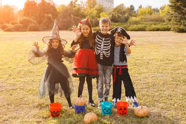 Scary cute children in Halloween costumes standing in field — Stock Photo, Image