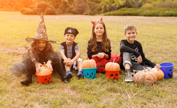 Funny kids with pumpkins and buckets on daytime — Stock Photo, Image
