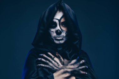 Kötü ruh göğsünde kollarını kavuşturuyor.