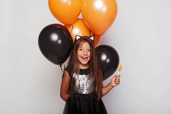 Linda chica riendo con dulces y globos — Foto de Stock