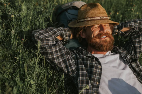 Baard reiziger ontspannen op gras in de natuur — Stockfoto