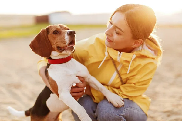 Mujer feliz abrazando perro divertido en la calle — Foto de Stock