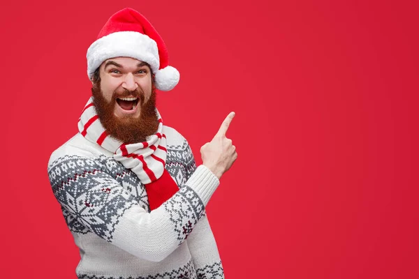 Homem excitado de chapéu de Pai Natal apontando para o espaço vazio — Fotografia de Stock