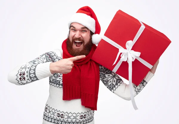 Homem animado apontando para o presente de Natal — Fotografia de Stock