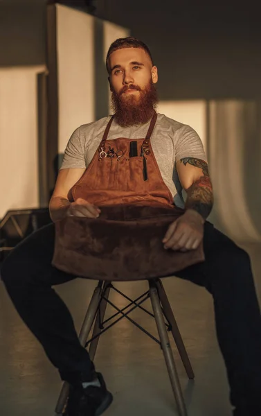 Relaxed barber sitting on chair