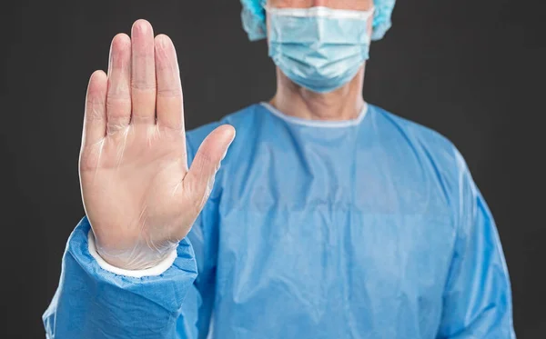 Доктор в защитной форме показывает стоп-жест — стоковое фото