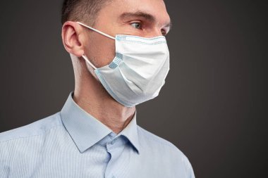 Koruyucu tıbbi maskeli yetişkin adam.