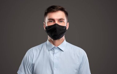 Koruyucu maskeli orta yaşlı bir adam.
