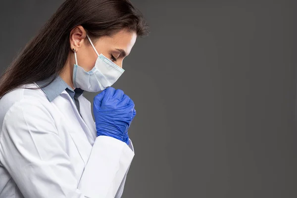 Kvindelig læge beder under COVID 19 pandemi - Stock-foto