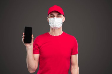 Erkek kurye akıllı telefondan dağıtım hizmeti uygulaması gösteriyor